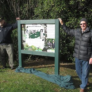 John left and Allan stand beside the new sign recognising their many years of work in restoring the health of Kew Bush.