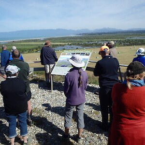 The SERN group looking towards Te Wae Wae Bay. The info board talks about the whitebait wetlands.